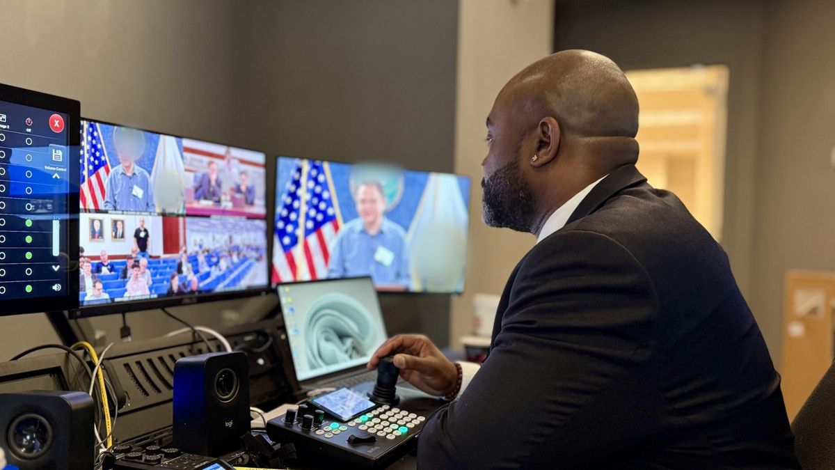 Operator running a live hearing broadcast from a multiview production control desk with a PTZ camera controller, by Enlightened Audiovisual